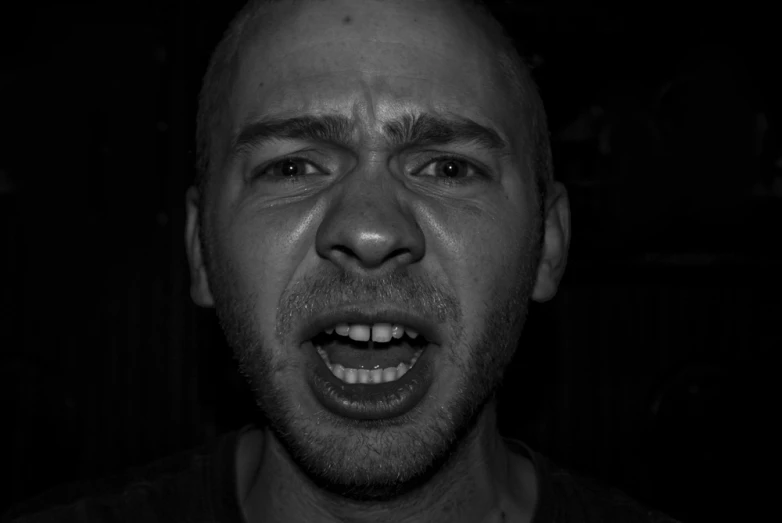 a man making a face with his mouth open in a black and white po