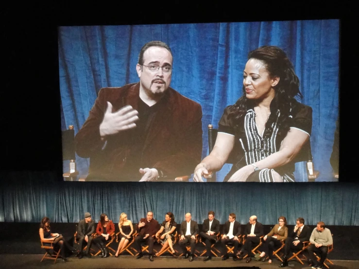 the panel at the conference is watching the screen