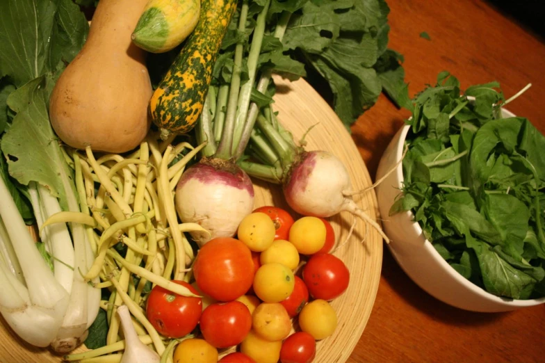 fresh vegetables are on a plate including broccoli, zucchini and tomatoes