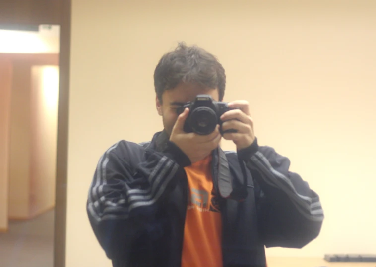 a boy taking a po in a mirror with a camera