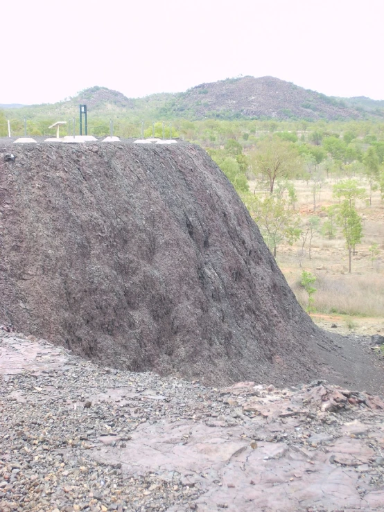 an industrial conveyor belt with a stack of dirt on top