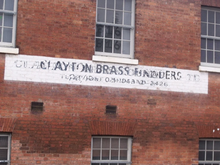 a brick building with many windows and a sign reading