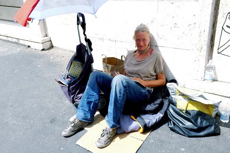 a woman sitting on the ground with an umbrella
