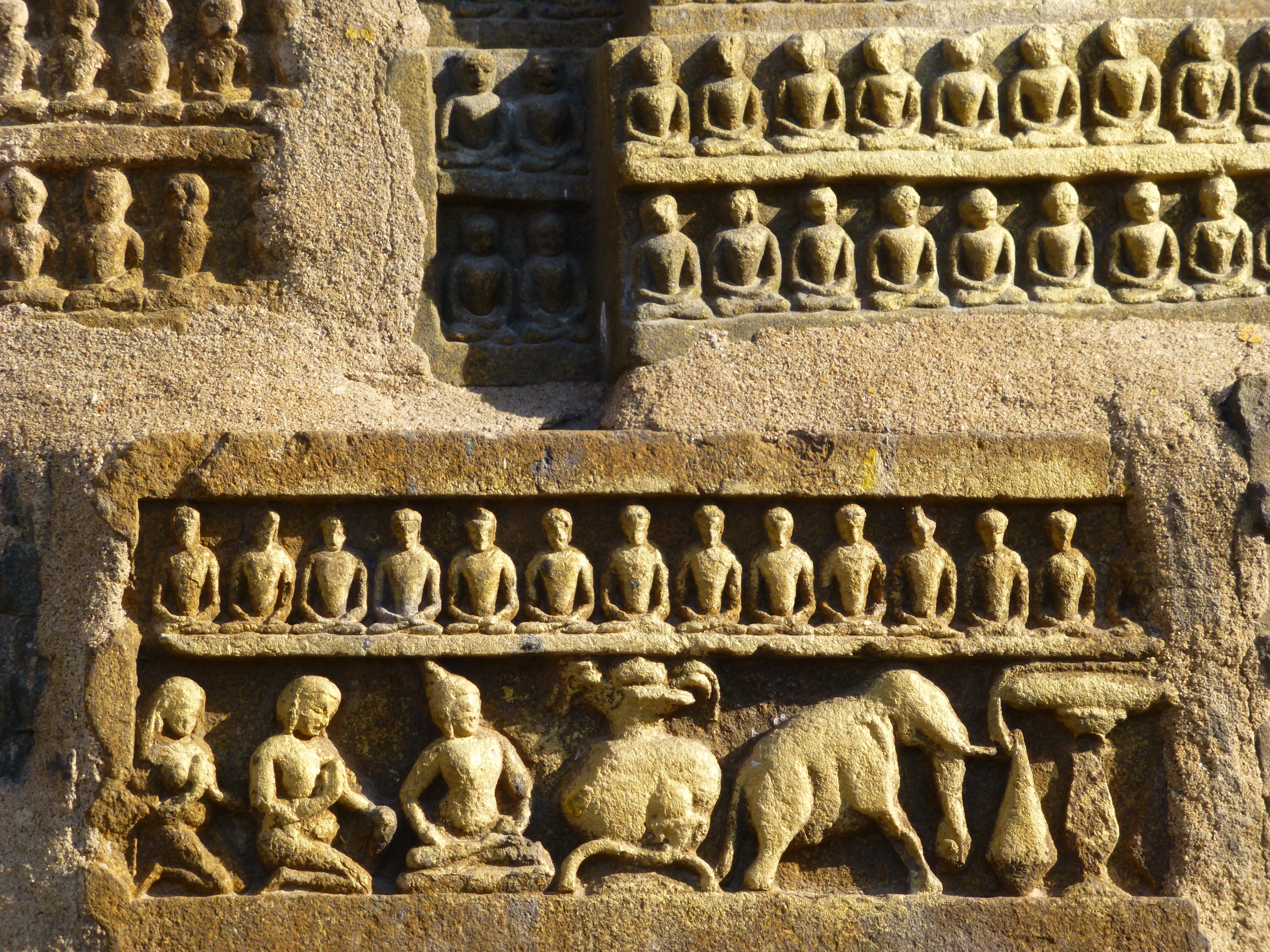 an intricately decorated stone wall with carved elephants and people