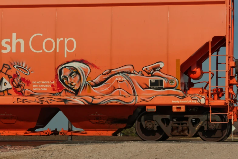 an orange train car painted with graffiti on the side