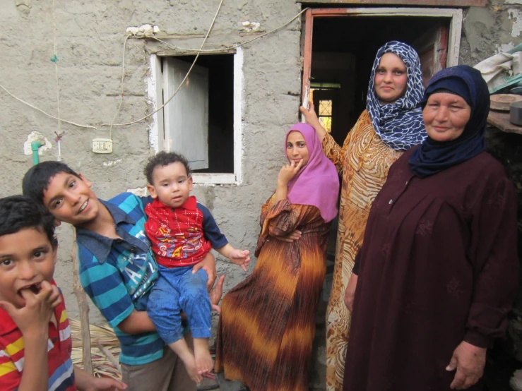 a family is posing for a po outside a house