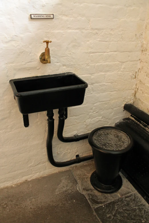 a black toilet and sink in a corner