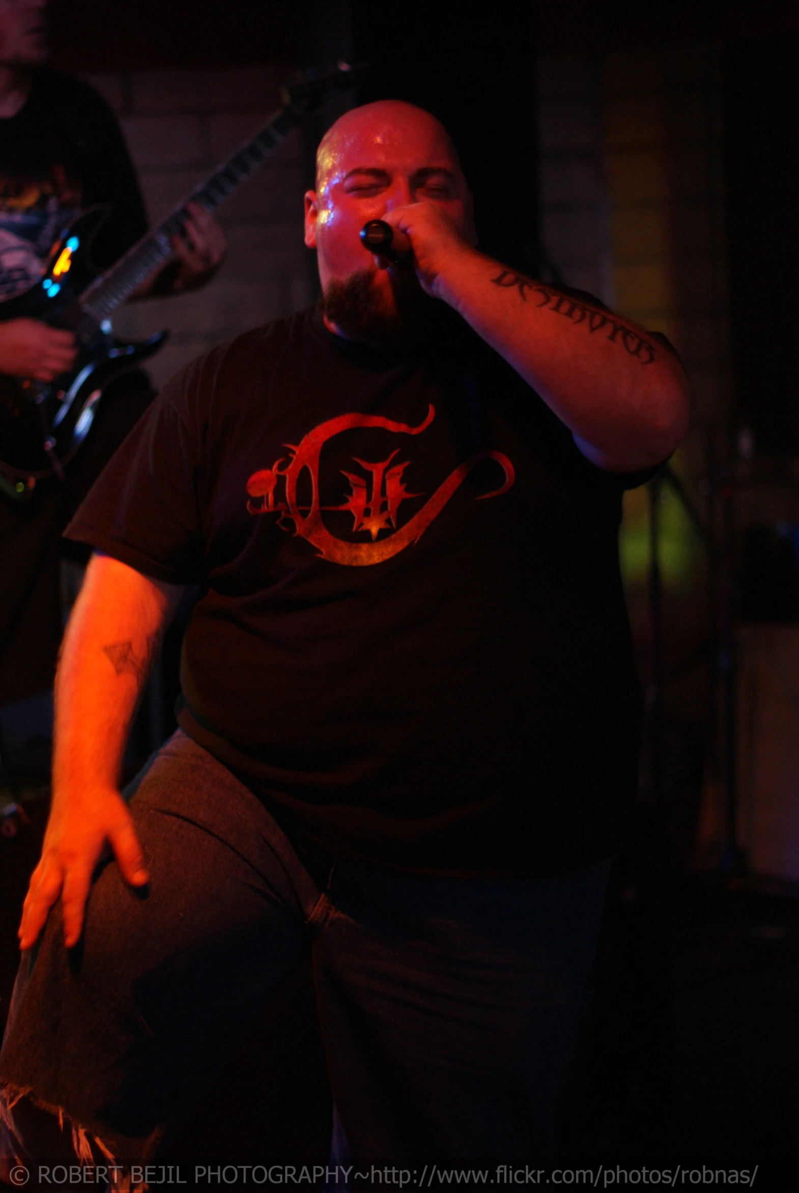 a man in black shirt playing a guitar on stage