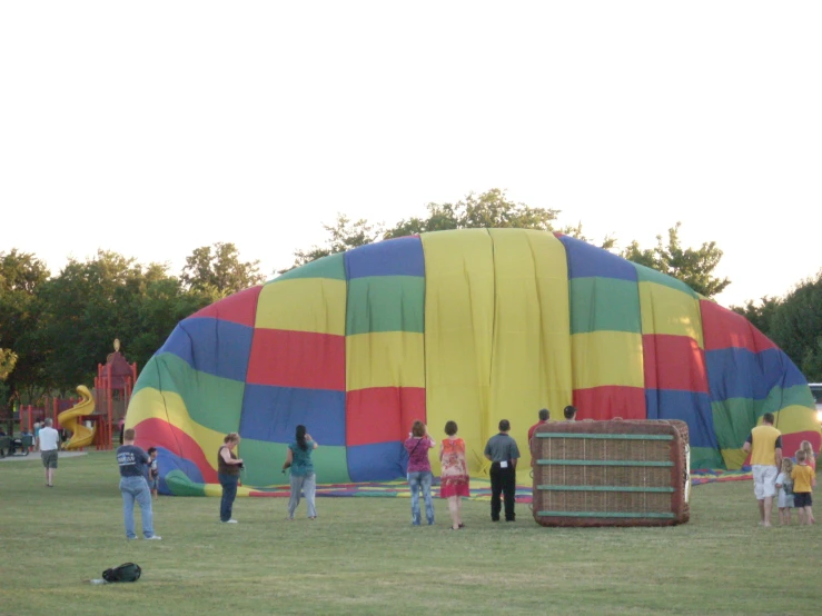 large multicolored air - filled balloon being watched by a group of people