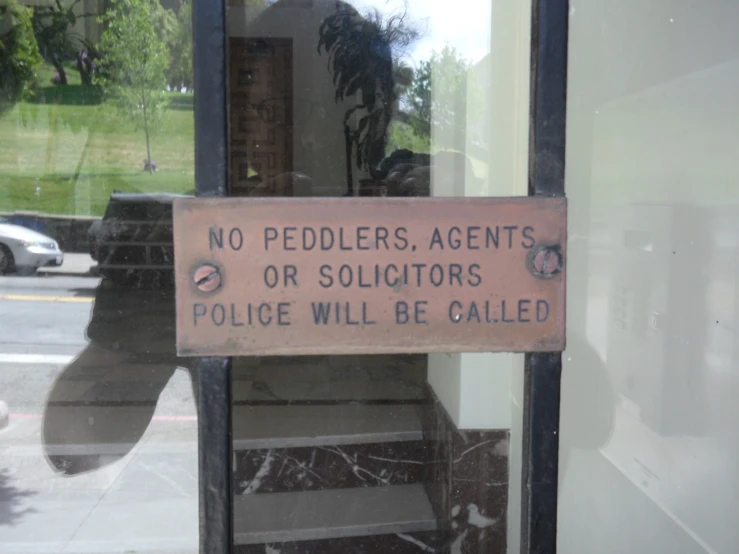 a sign posted in the doorway to a building saying that no peddlers, agent or soldiers who will be called