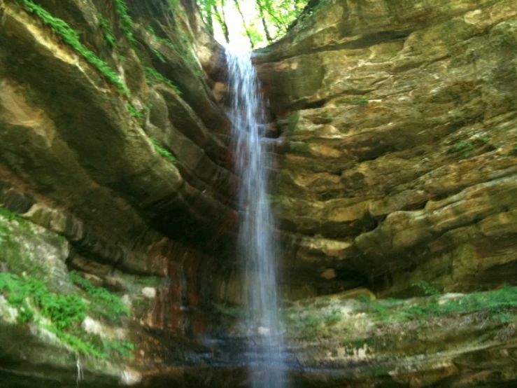 a view of a waterfall and some green vegetation