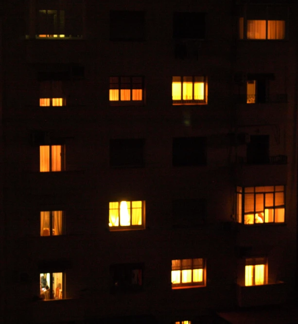 some windows lit up at night in the dark