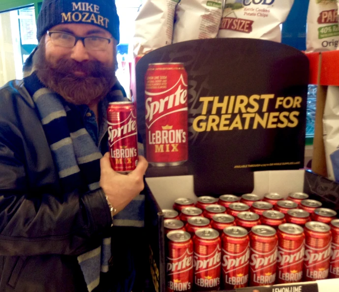 a man holding a bottle of beer in front of a display