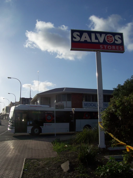 a salvation's store sign next to a white bus