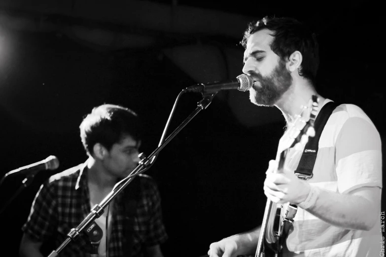 two men with musical instruments playing on stage