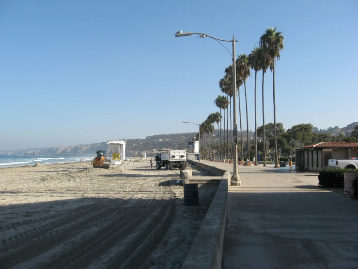an empty beach with some palm trees near by