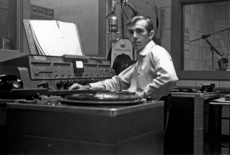 a man is sitting at a turntable in front of microphone