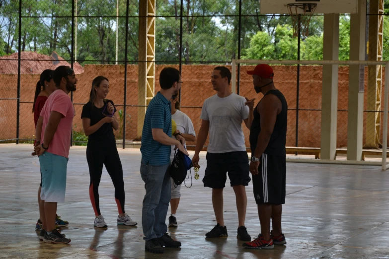 group of young men and women chatting in an indoor arena