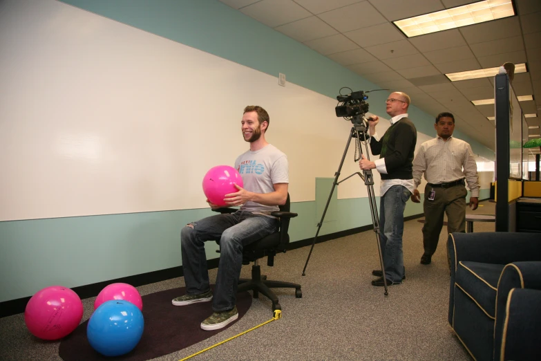 a person sitting down with a camera behind them in front of a tv