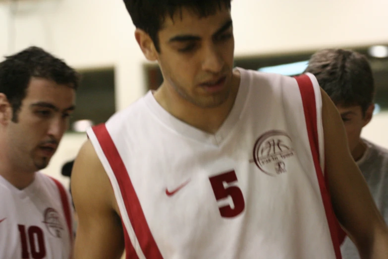 two basketball players in uniform walk together