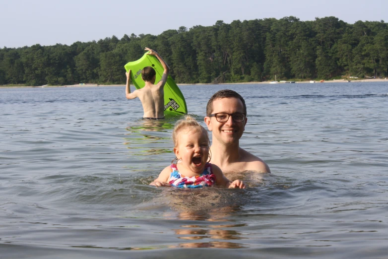 a man and girl float on their back in water with life vests
