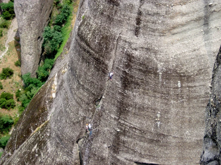 the view of a man climbing on a very large rock