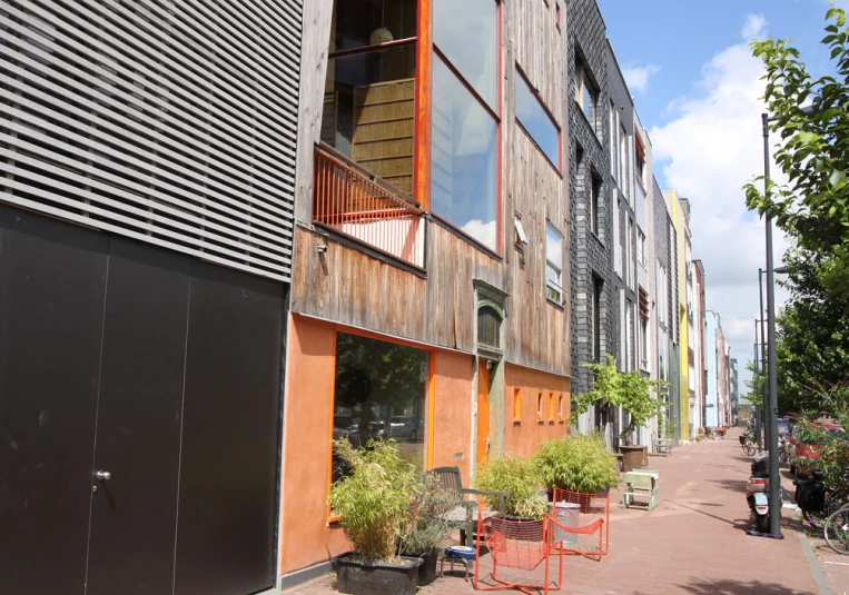 two red chairs sit outside a two - story building