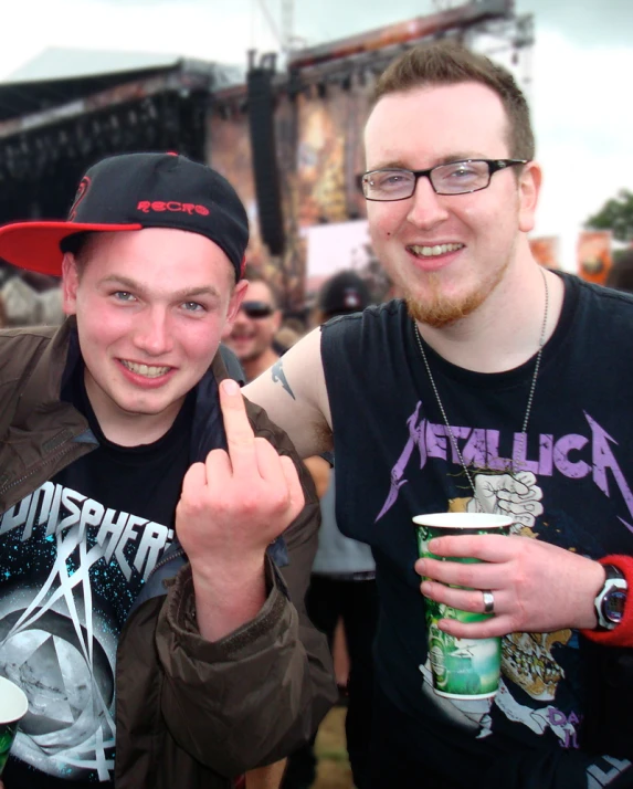 two guys wearing sunglasses and shirts making a thumbs up sign