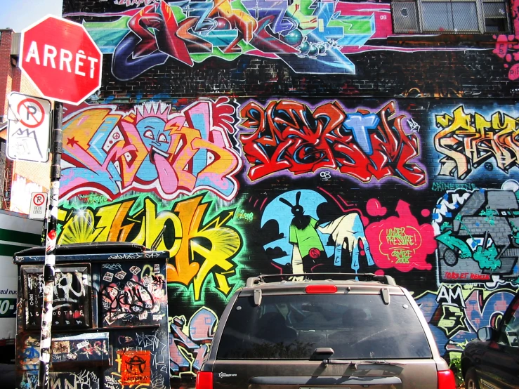 a car parked by a building with graffiti all over it