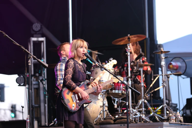 two women on a stage singing and playing guitar