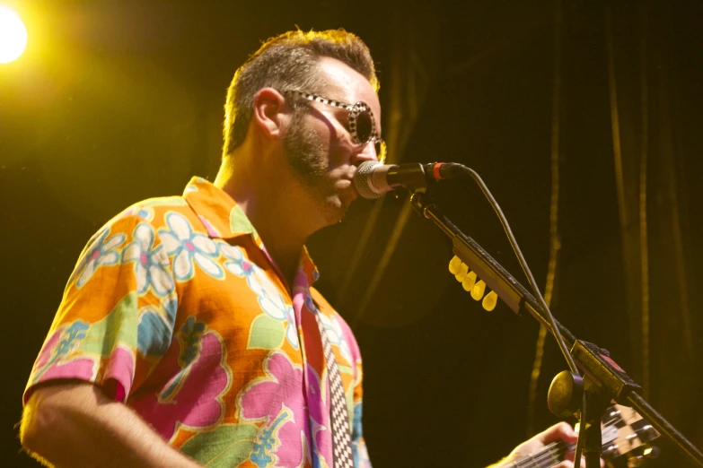 a man with a guitar playing at a music concert