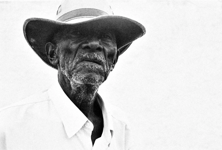 a close up of a man wearing a hat and a shirt