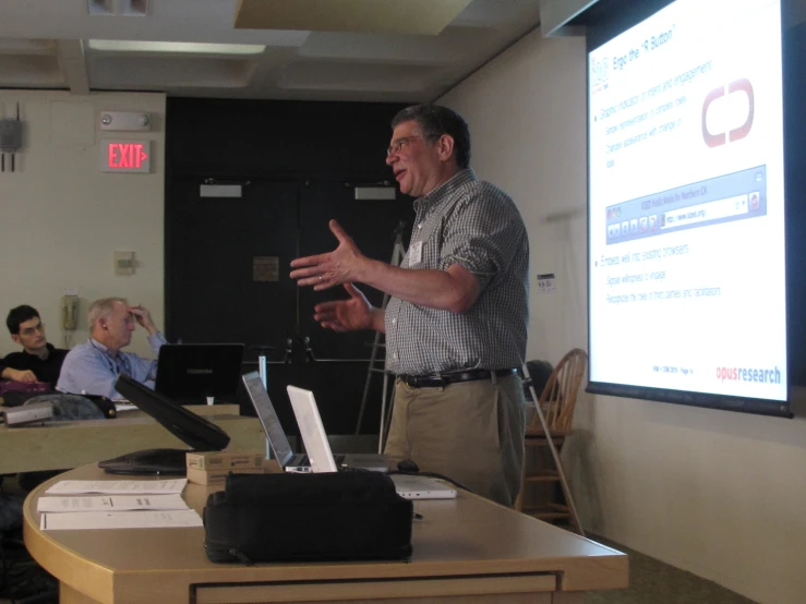 a man standing in front of a group of laptops