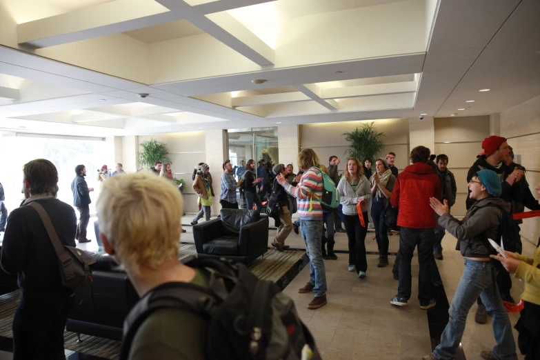 a bunch of people are standing around in an airport lobby