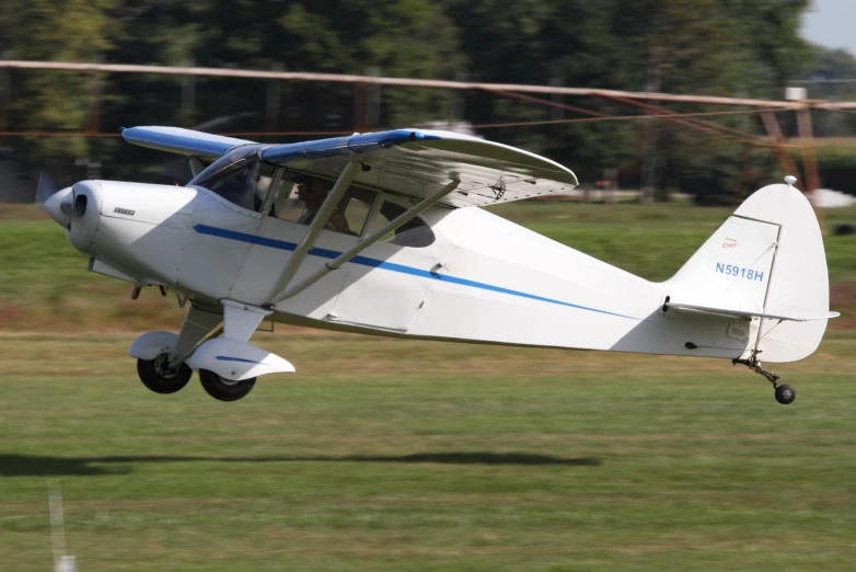 a plane flying low over some grass