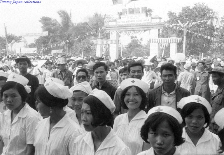 a group of people wearing white hats standing in front of an arch