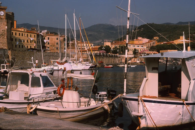 several small boats in a harbor in front of large buildings