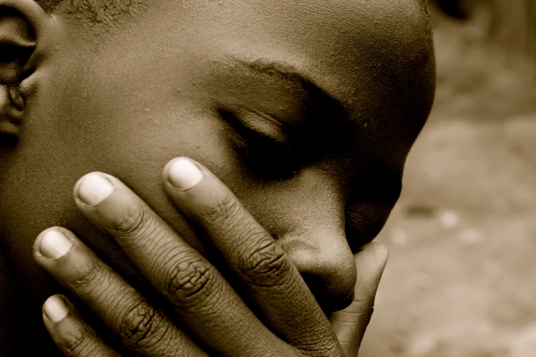 a young person with one hand on his face