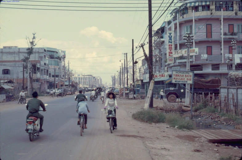 a group of people riding motorcycles down the middle of a road