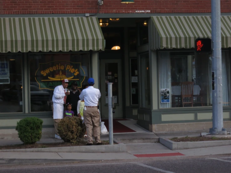 the store has three customers outside on the street corner