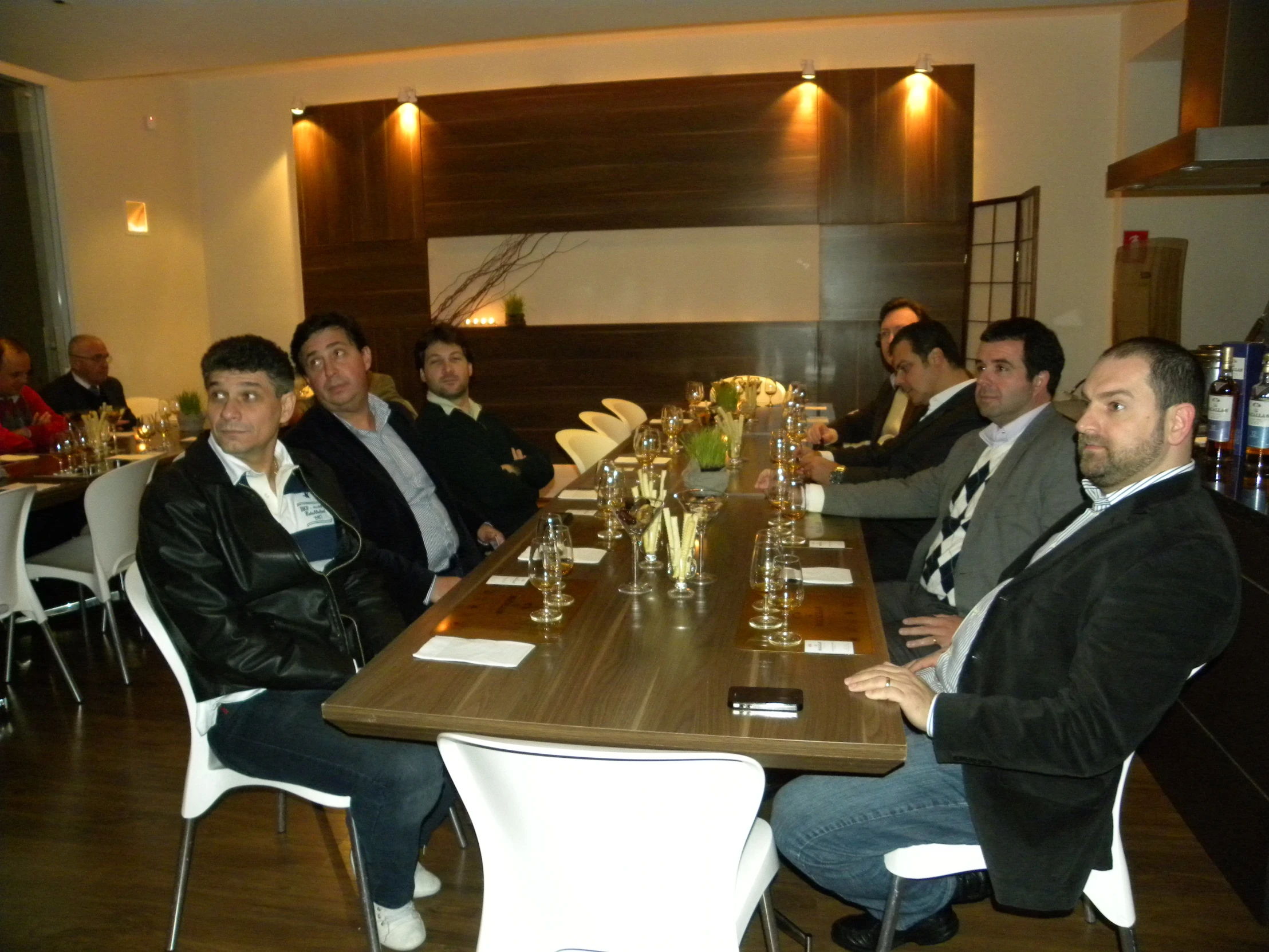 some men in tuxedos sit around a table together