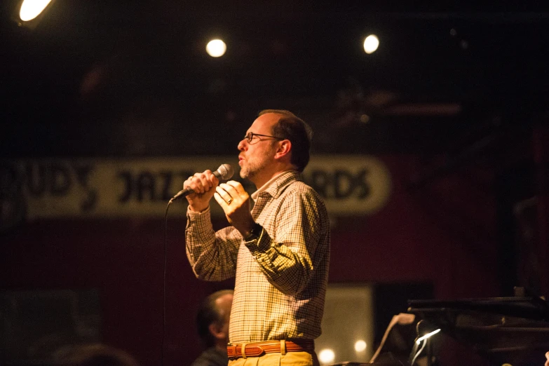 a man that is standing up with a microphone