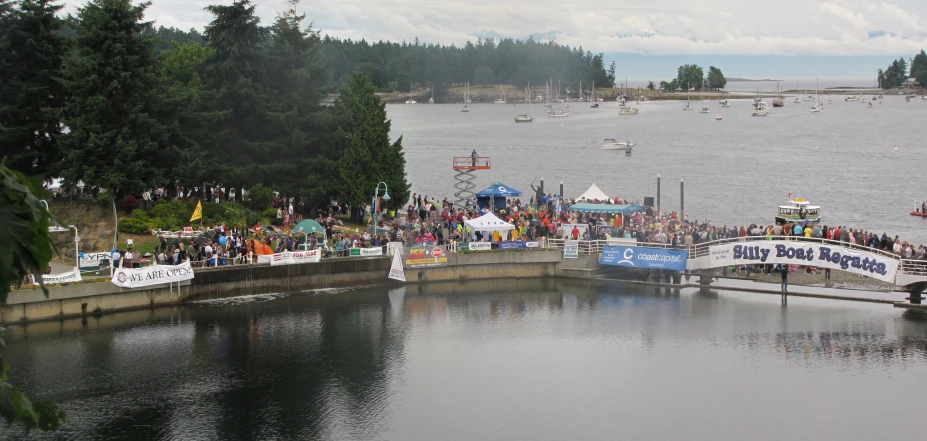 several boats with spectators sitting on the side of a river