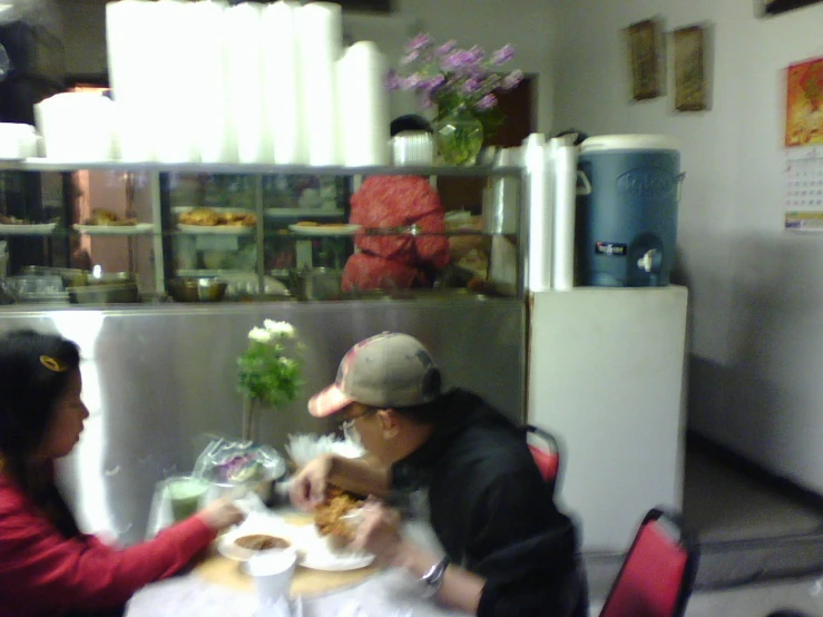 people sitting at a table eating some food