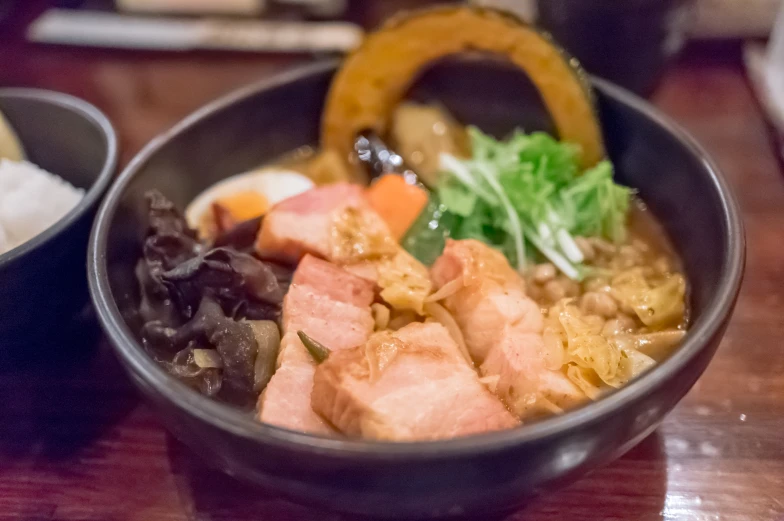 bowls of assorted sushi and a pastry sitting on the table