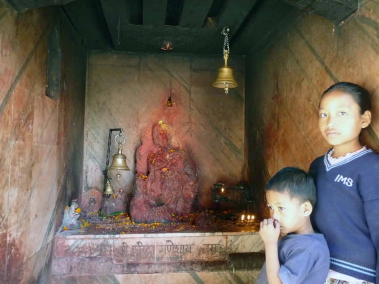 two boys in an ancient shrine with bells