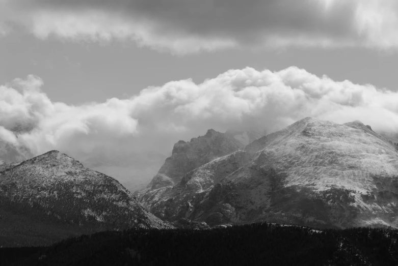 mountain range with snow and clouds in the distance