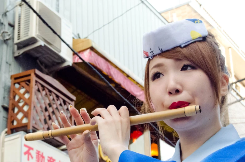 a woman in a blue shirt is playing flute