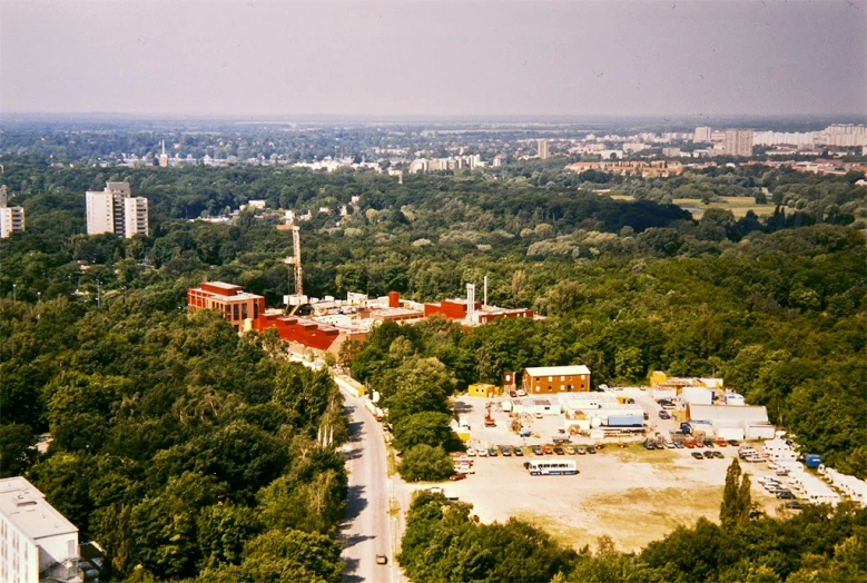 an aerial view of a parking lot surrounded by trees and tall buildings