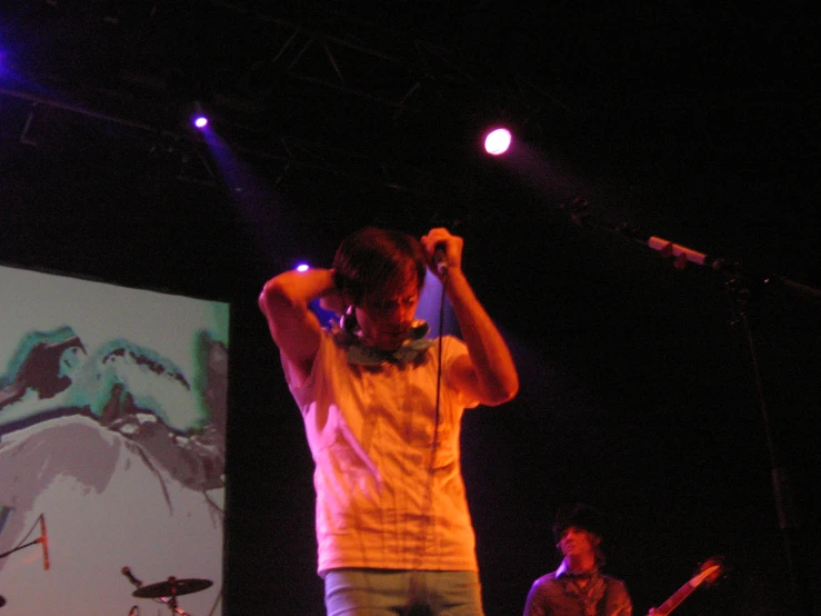 a man standing next to a drummer on a stage